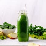 Bottle of green blender smoothie with apples, spinach, kale and celery