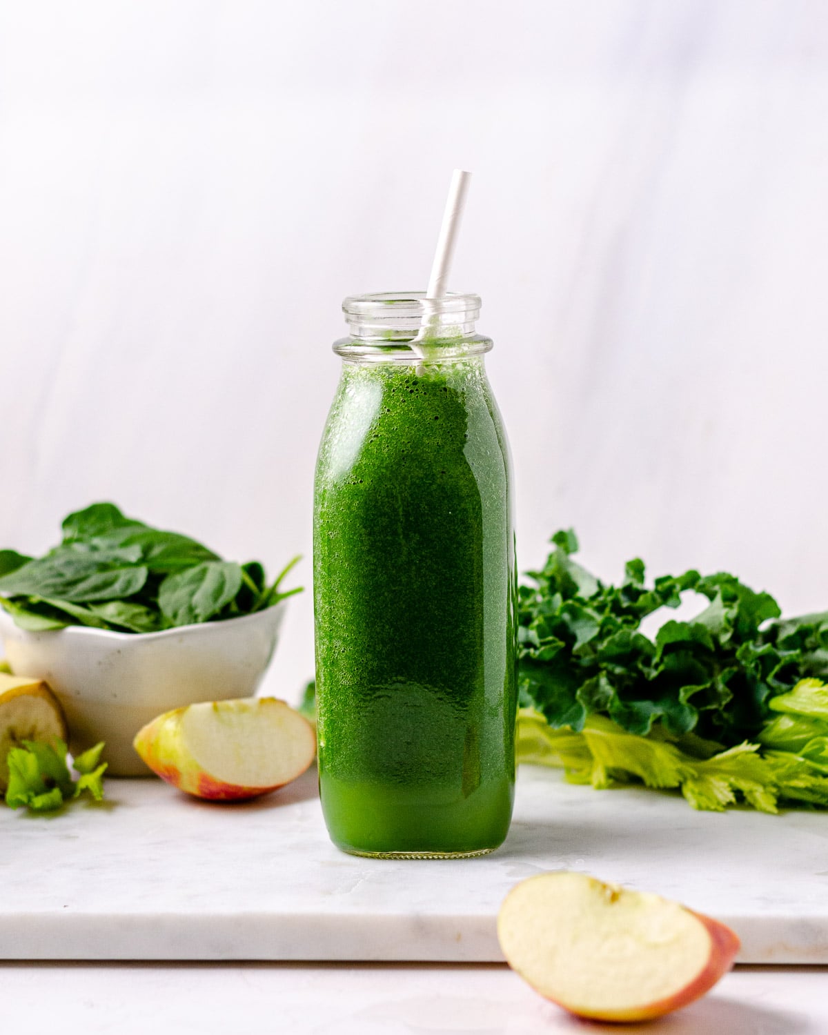 Bottle of green blender smoothie with apples, spinach, kale and celery