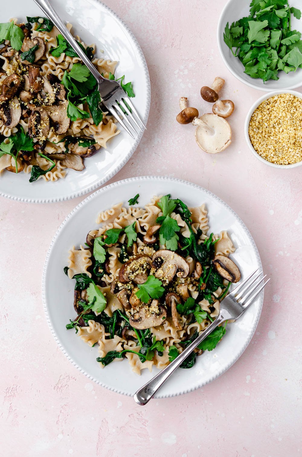 Mushroom truffle pasta with baby spinach, garnished with cashew parmesan and parsley.