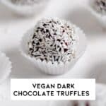 Close up of a vegan dark chocolate truffle coated with coconut flakes in a wrapper