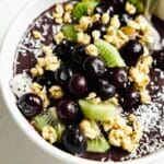 Close up of an açaí bowl topped with blueberries, kiwi, coconut flakes and granola