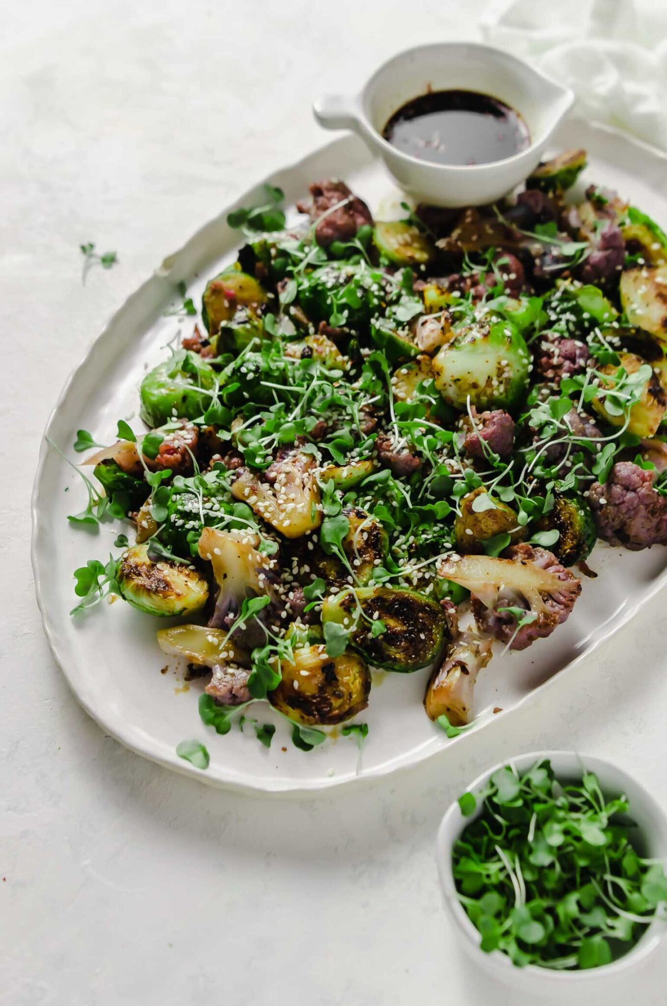 Honey Soy Brussels sprouts which have been garnished with sesame seeds and broccoli sprouts