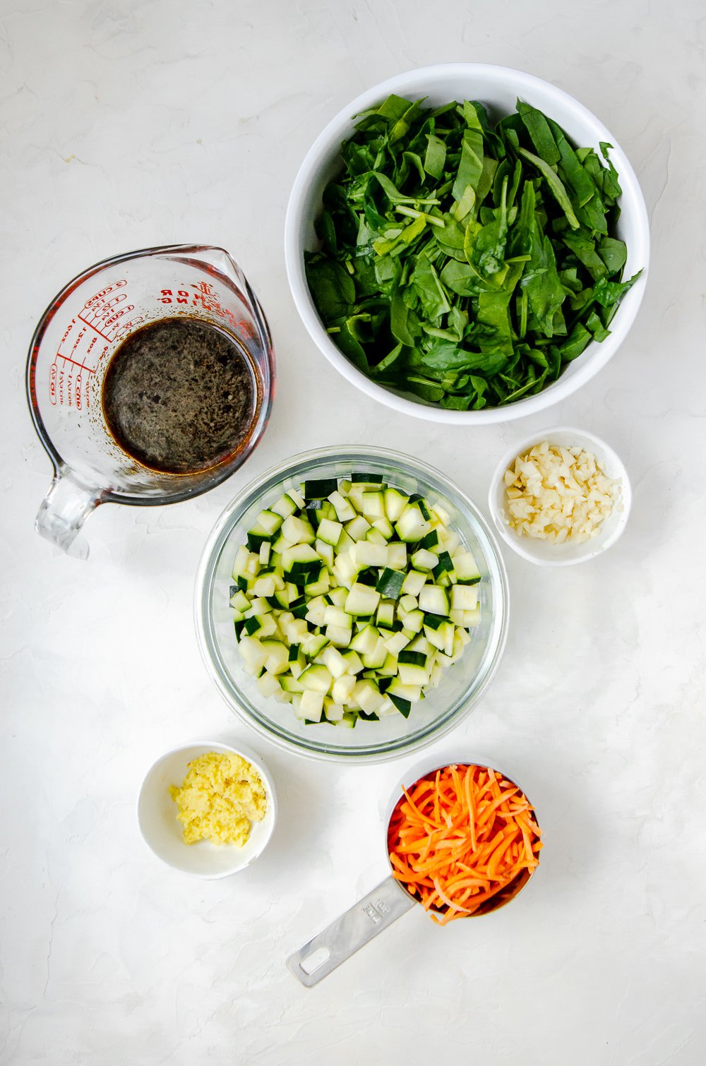 Ingredients for chicken larb bowl including baby spinach, coconut aminos, zucchini, garlic, ginger and carrot