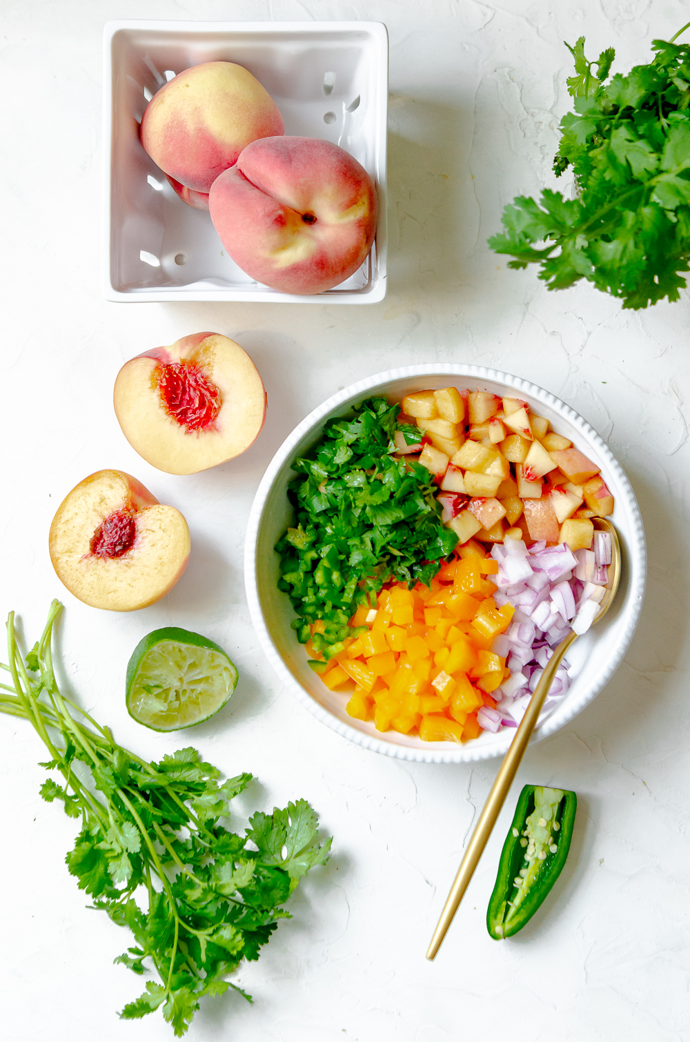 Ingredients for the peach salsa including peaches, cilantro, lime, jalapeno. 