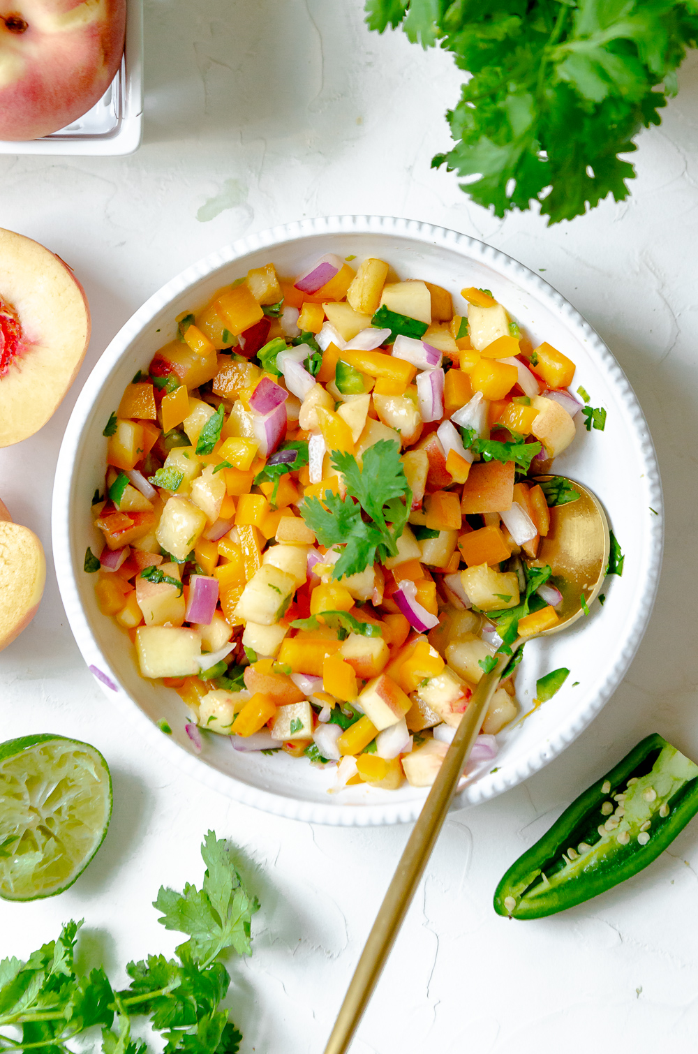 A bowl of peach salsa made with peaches, cilantro, red onion and jalapeño. 